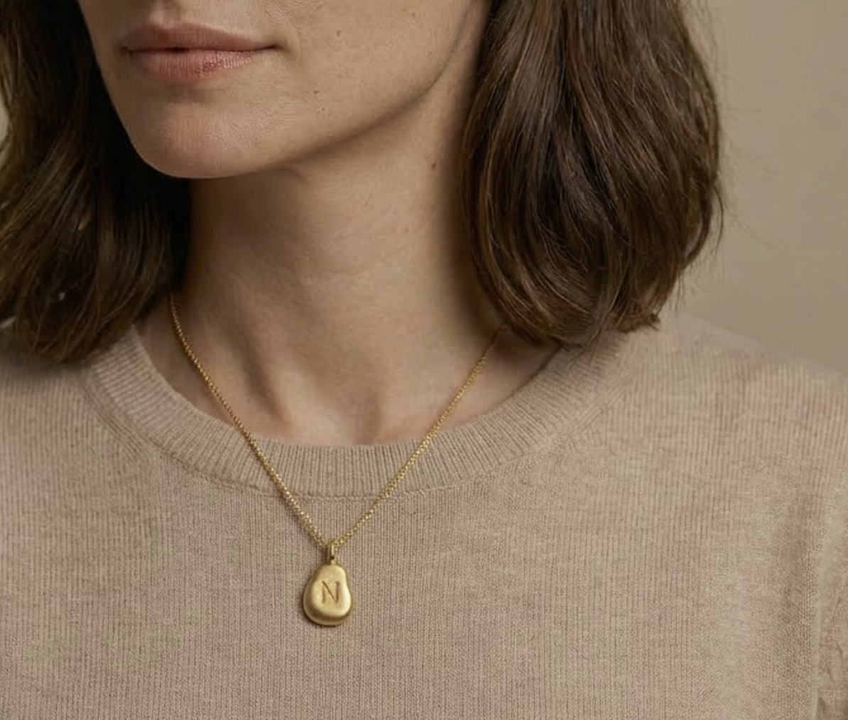 Sarah modeling a gold pendant necklace